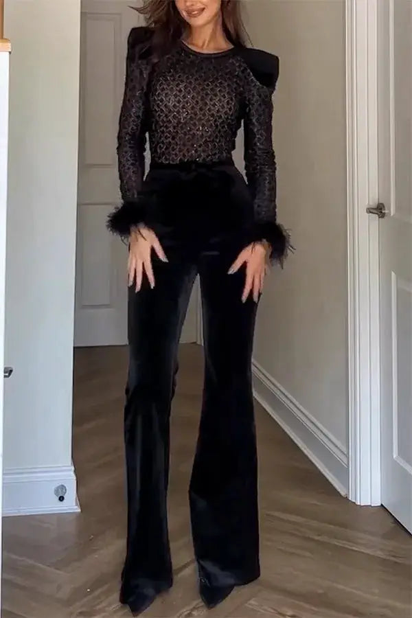 Black jumpsuit with sheer lace top and velvet pants; sleeves with feathered cuffs
