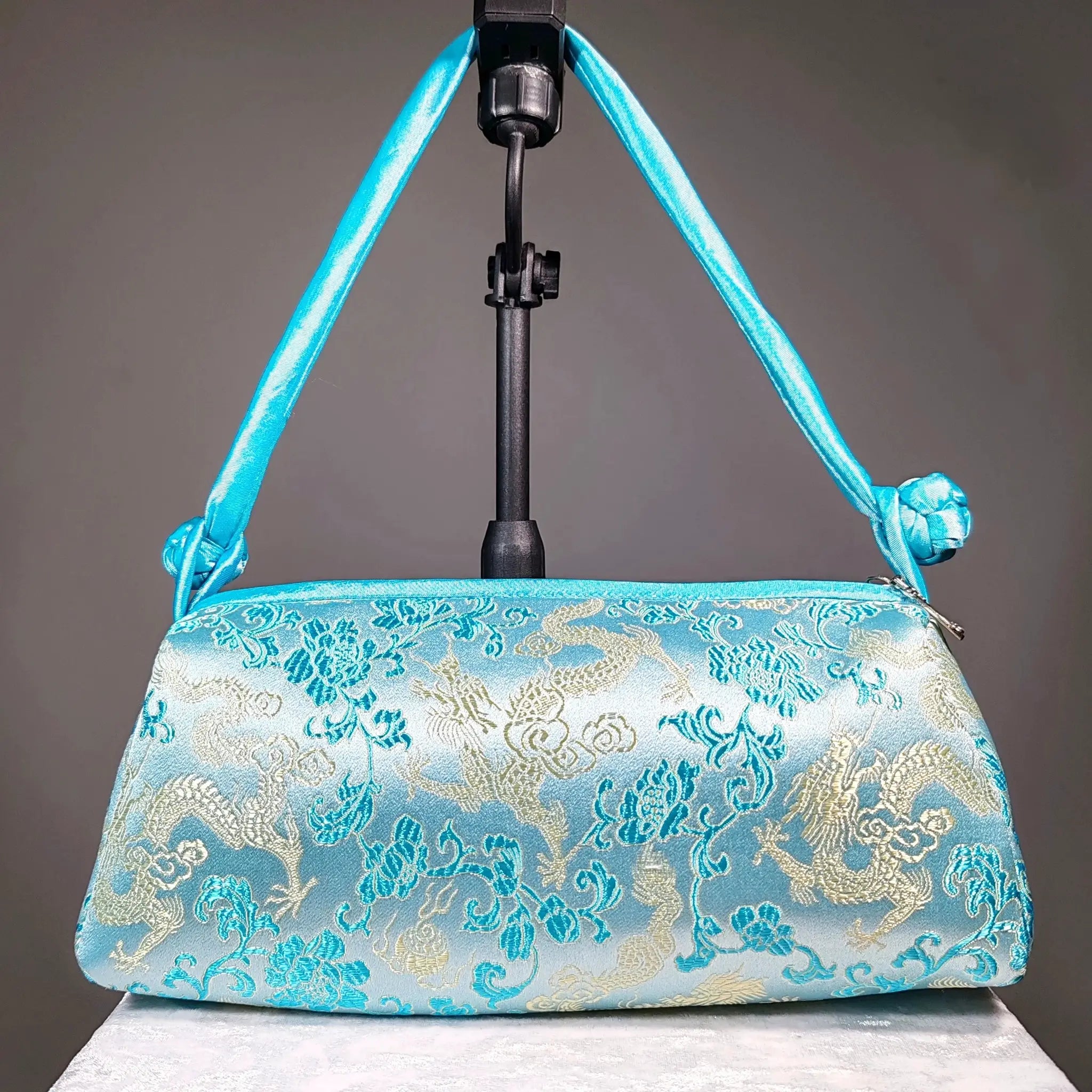 Blue silk embroidered shoulder bag with turquoise straps and gold floral pattern
