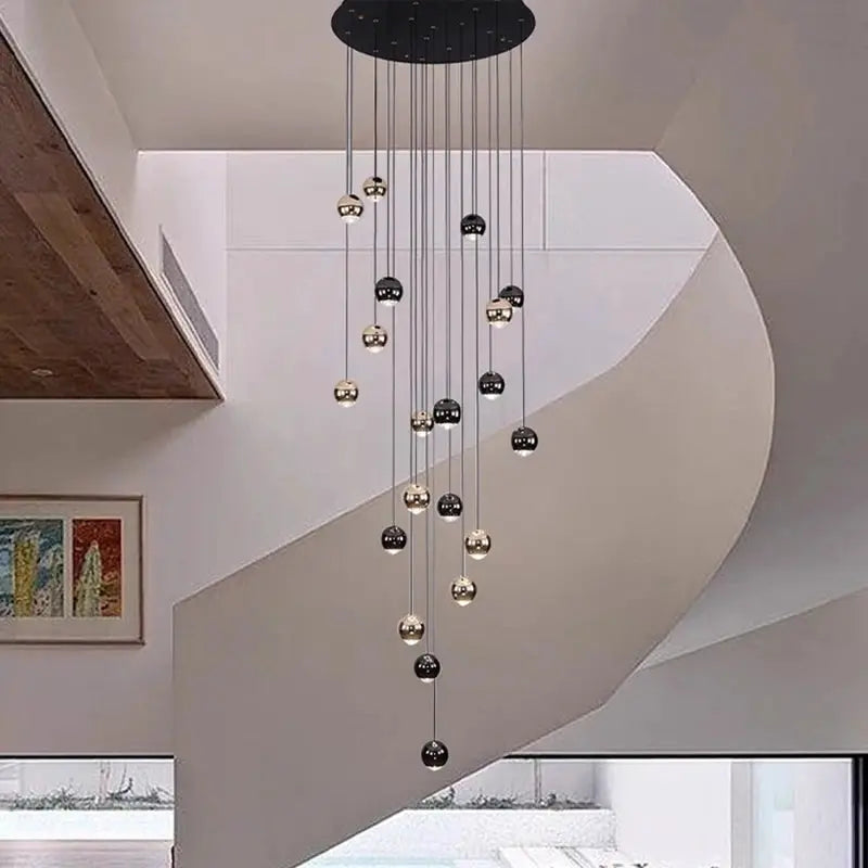 Modern pendant light fixture with cascading black and gold metal sphere LED pendants
