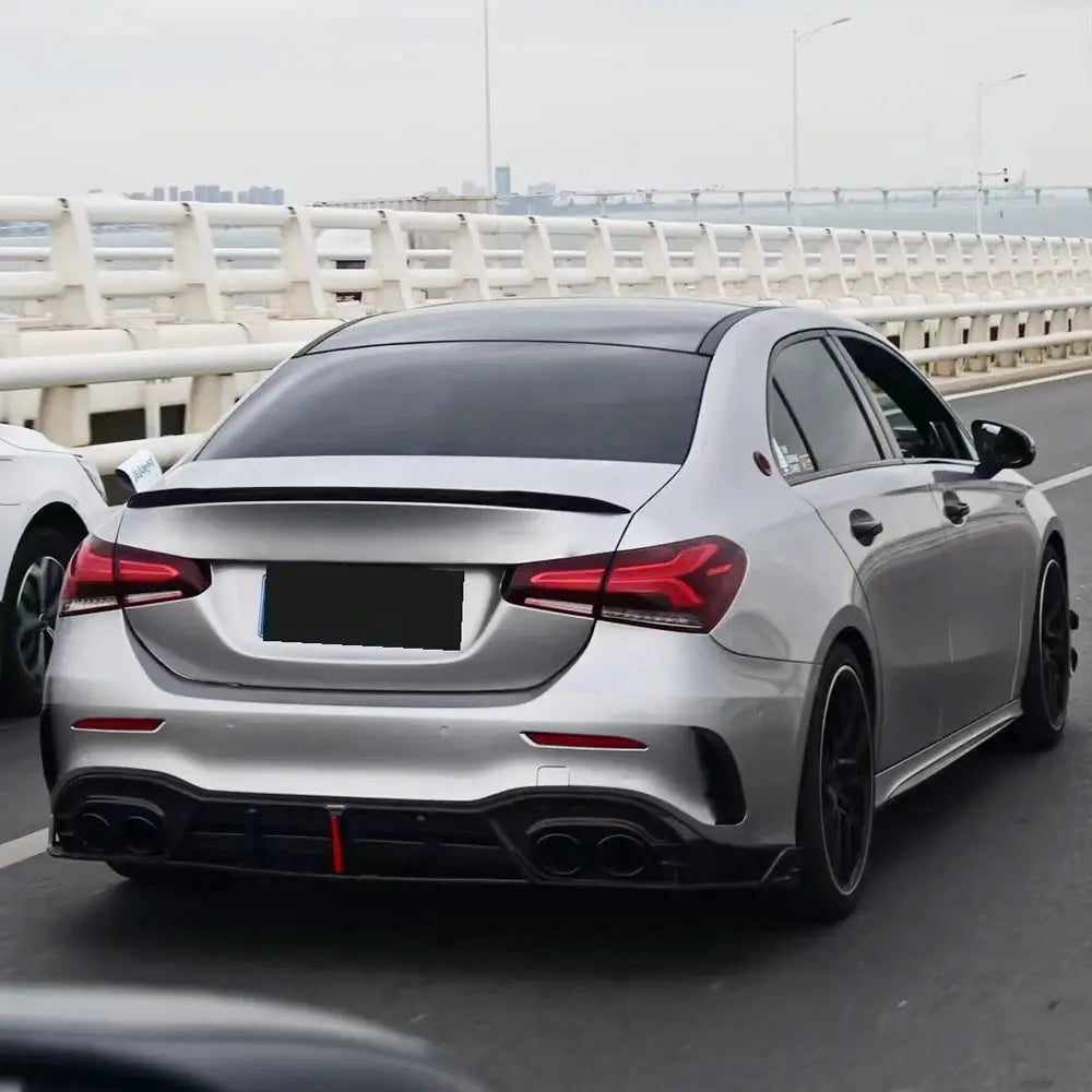 Rear trunk spoiler, black carbon-fiber look, on a silver sedan