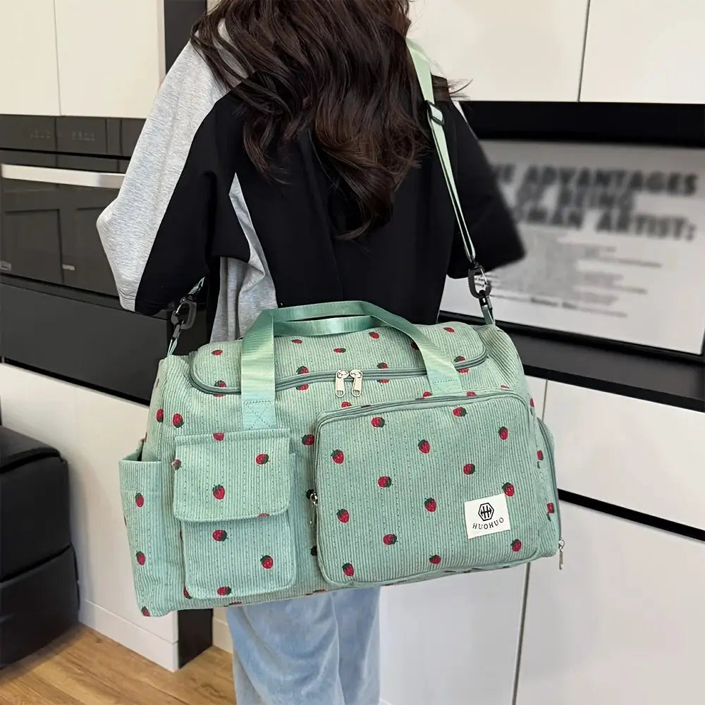 Strawberry travel bag by Simples Market, mint green corduroy luggage with front pocket and crossbody strap.