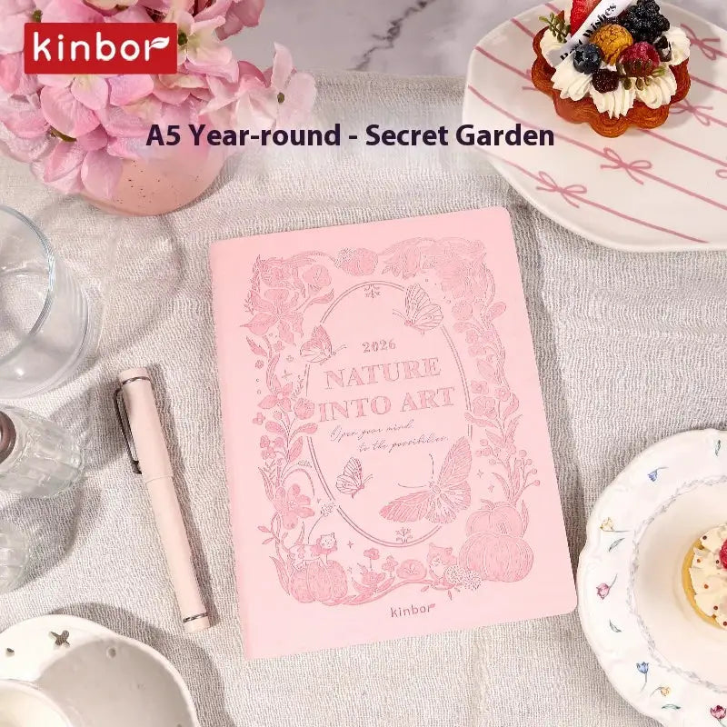 Kinbor pink notebook planner with nature into art cover on a table with a pink pen