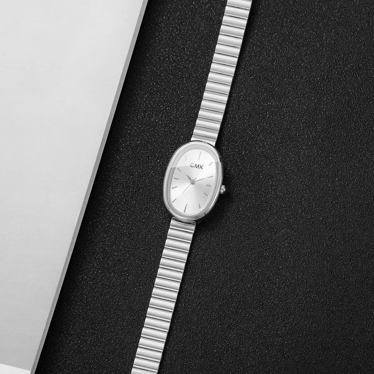 CMK women's oval-dial analog quartz wristwatch with a slim silver metal strap