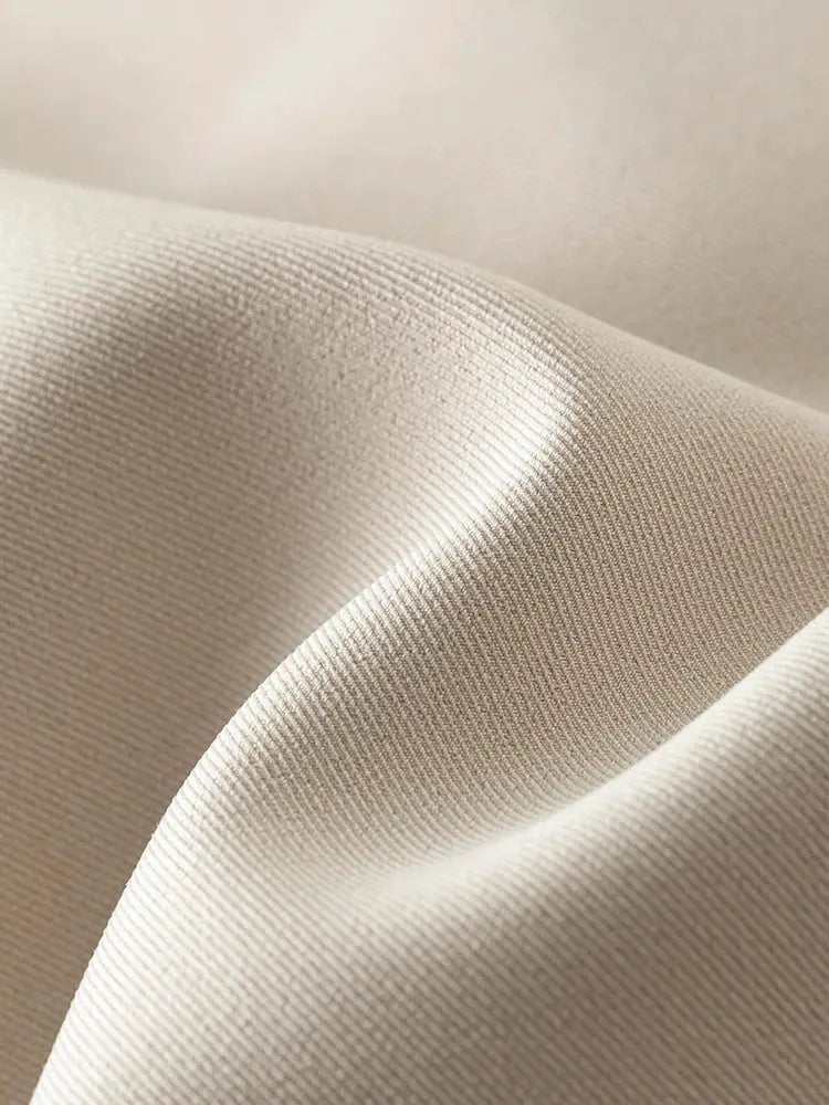 Beige blazer fabric close-up showing a tight, uniform weave texture, ideal for a formal office outfit.