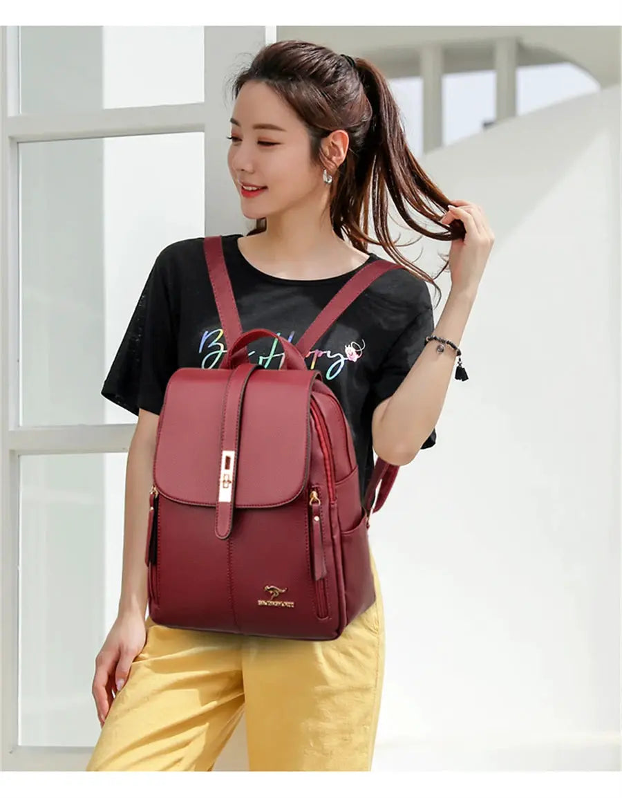 Leather burgundy backpack for women with front flap and gold-tone hardware.