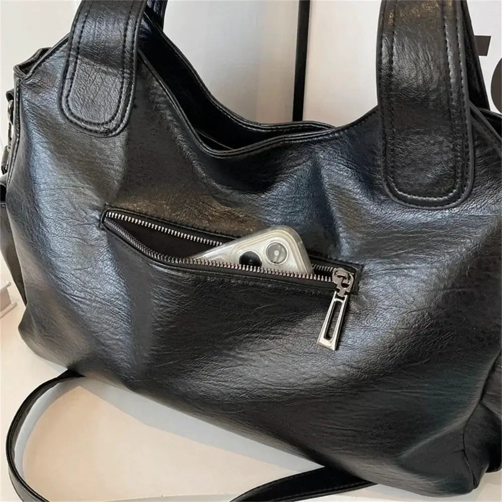 Black PU leather shoulder bag with front zip pocket, dual top handles, and silver hardware