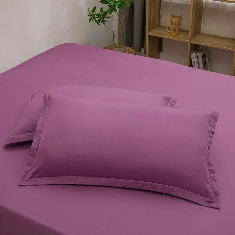 2-pack purple pillowcase set in solid color on a purple bed sheet