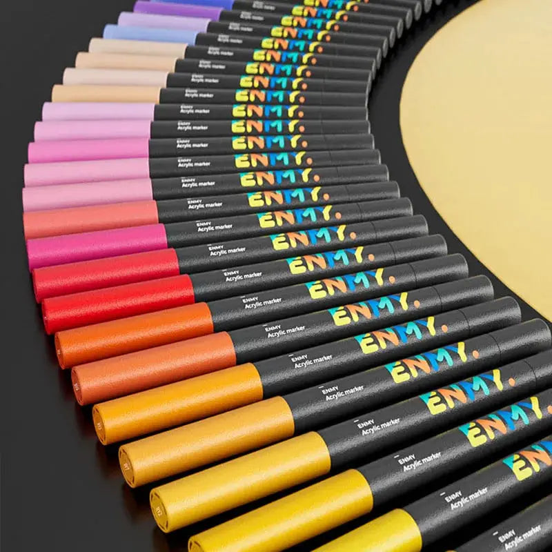 ENMY acrylic paint markers set in assorted colors; black barrels with ENMY branding, curved around a yellow palette.