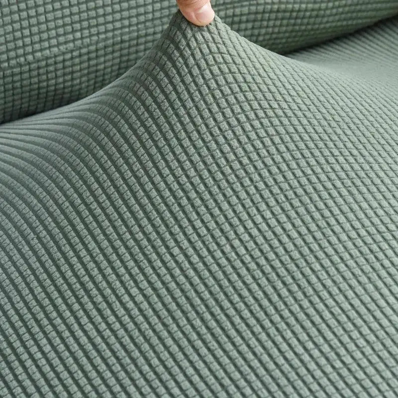 Elastic sofa cover in sage green textured grid fabric by Simples Market for living room couches