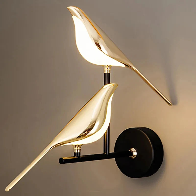 Magpie Bird wall lamp pair: gold metal LED sconces on a black mount by Simples Market.