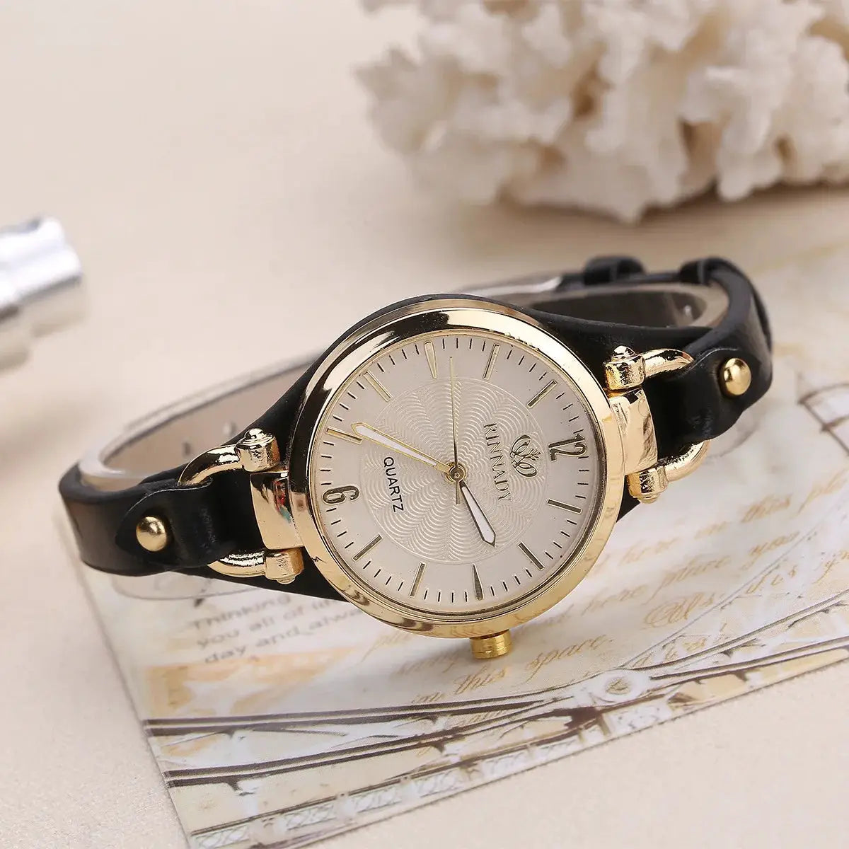 Women's minimalist luxury quartz watch by Simples Market with black leather strap and gold-tone case.