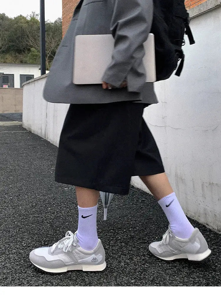 Mauroicardi black loose high-waist shorts for men, paired with white Nike socks and gray sneakers