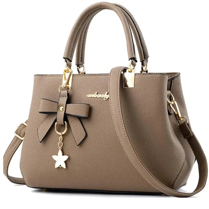 Taupe pebbled women's handbag with bow accent and star charm, dual top handles and detachable strap