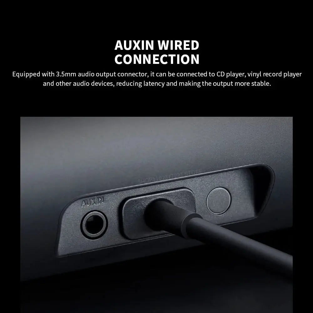 Black Redmi computer speaker back panel with AUX IN jack and plugged cable