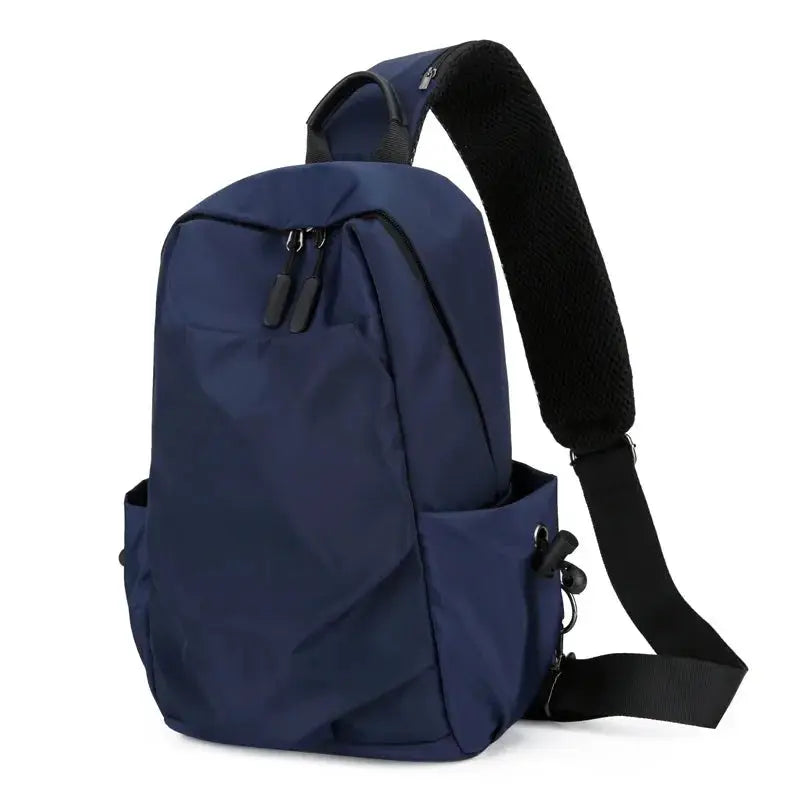 Men's navy blue canvas crossbody chest bag with adjustable padded strap and side pockets.