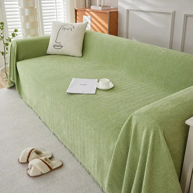 Couch cover in light green chenille with fringe and herringbone texture