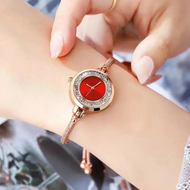 Women's gold-tone bracelet watch with red small dial and crystal bezel
