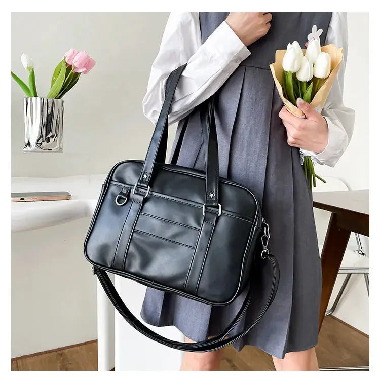Japanese style JK bag in black PU leather with dual top handles and detachable crossbody strap.