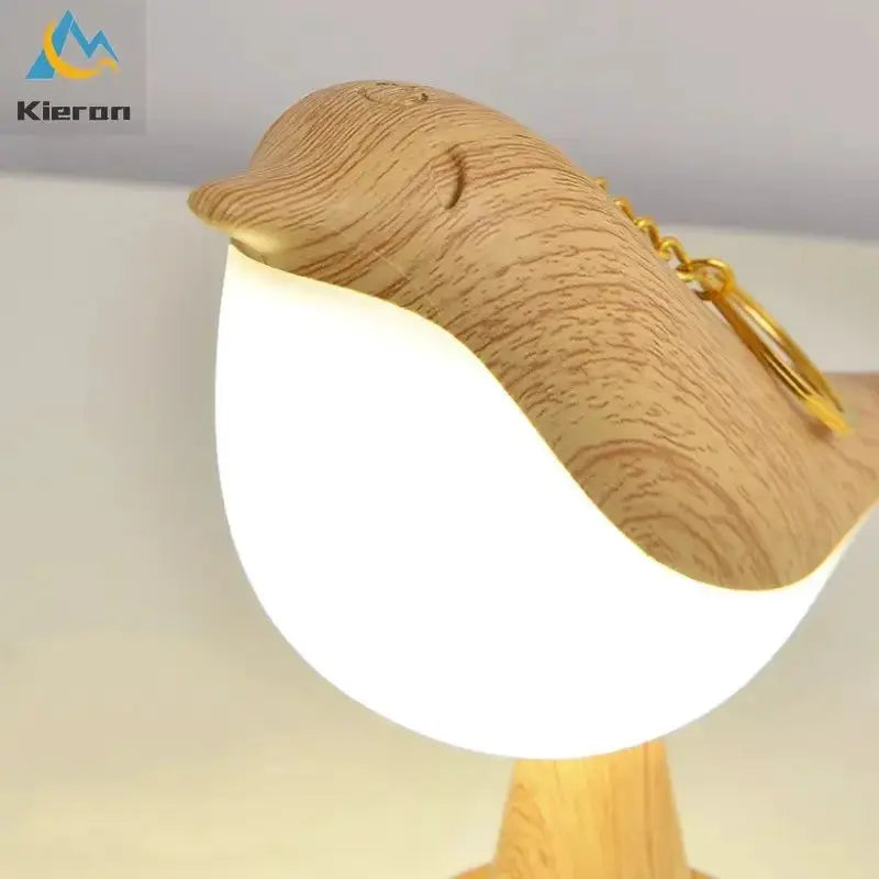 Nordic Magpie LED desk lamp with wood-grain curved top and white glow; Kieron logo visible