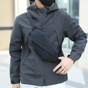 Simples Market waist bag crossbody chest bag in black, worn over a gray outdoor jacket