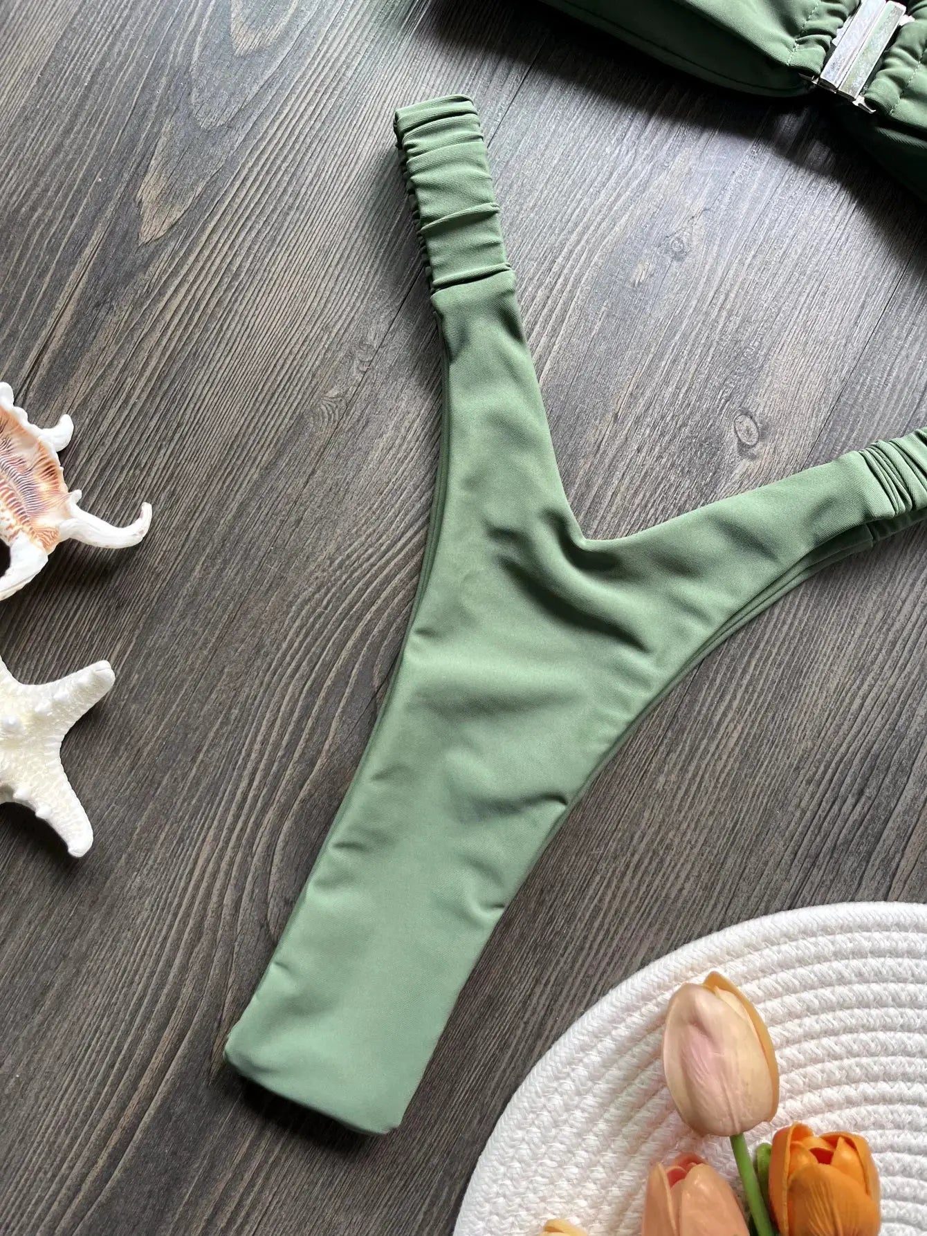 Green thong bikini bottom with ruched sides for beachwear