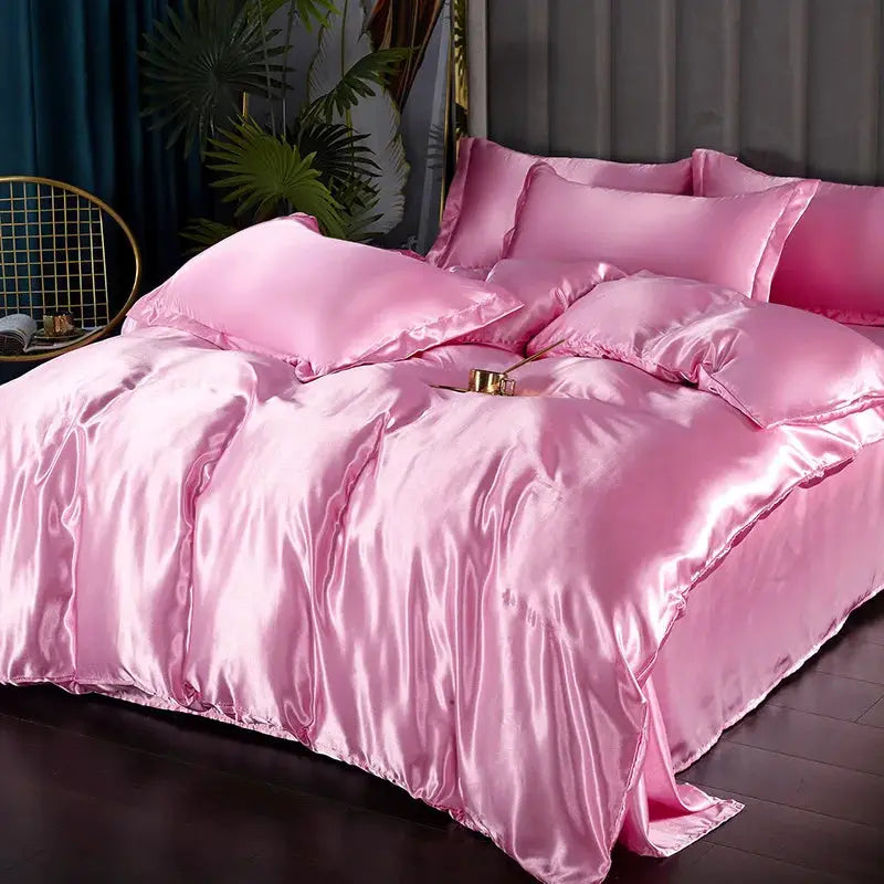 Simples Market pink satin bedding set with duvet cover, sheets and pillowcases on a bed.