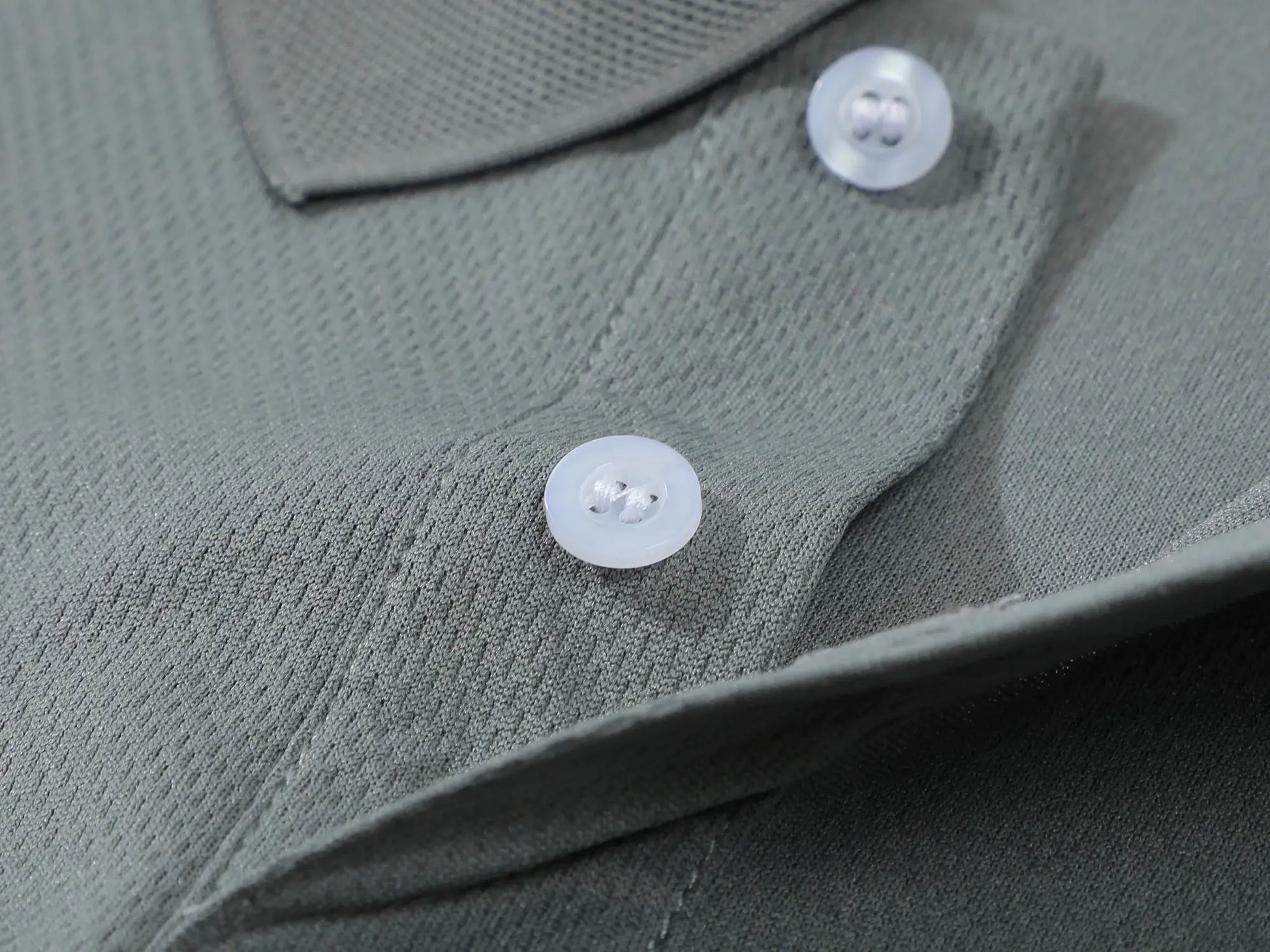 Men's solid-color polo shirt; close-up of textured knit fabric with two white buttons.