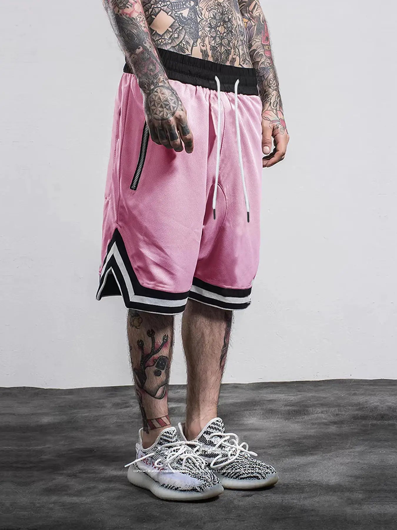 Men's pink mesh quick-dry basketball shorts with black waistband, white drawstrings, and side zip pocket