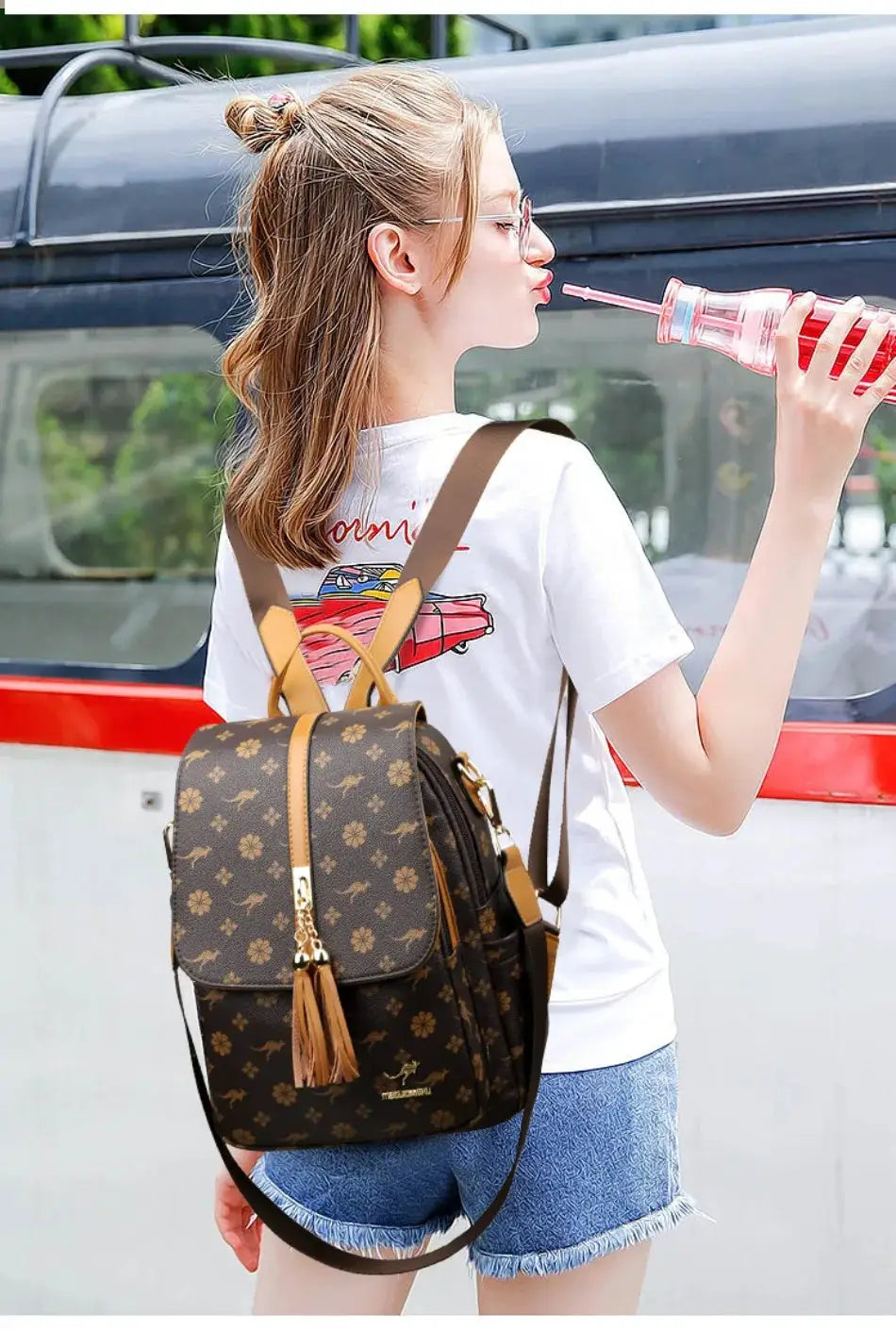 Ladies leather backpack with brown floral monogram, tan straps and tassel zipper pull