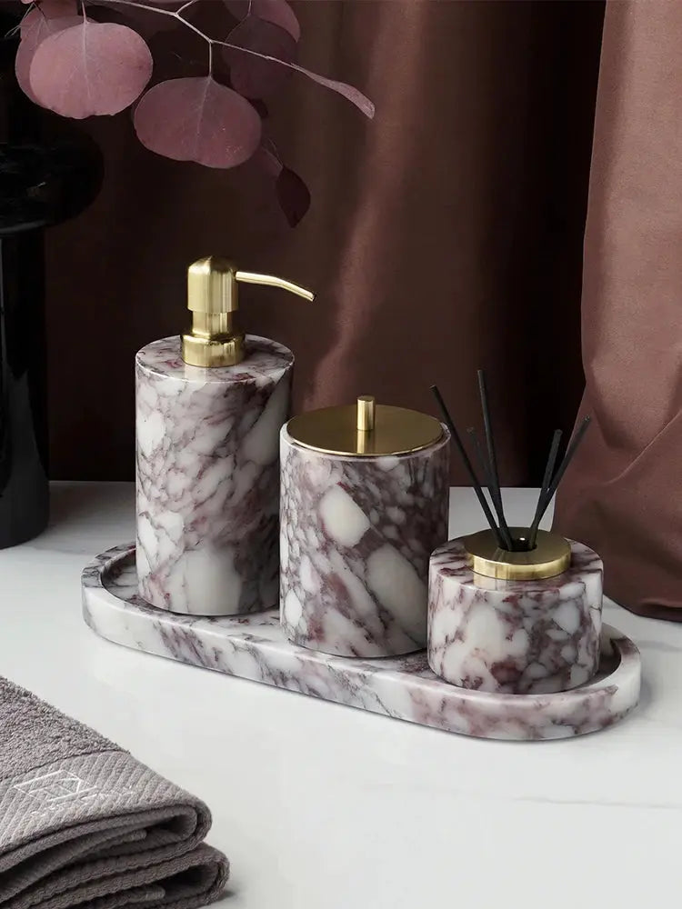 Calacatta Viola marble bathroom set on a matching tray with a gold-pump soap dispenser, canister, and reed diffuser.