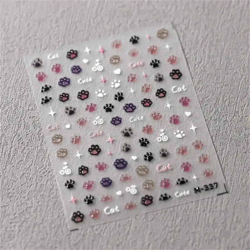 Nail art sticker sheet with self-adhesive paw prints, hearts and stars in pink, purple, white on clear background