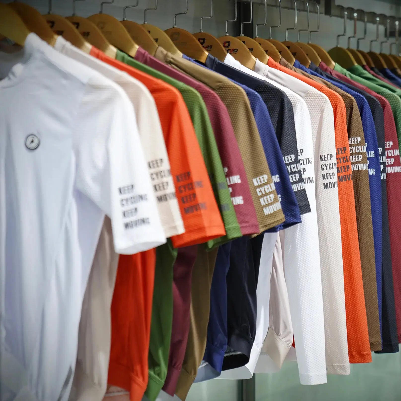 DAREVIE cycling jerseys on display, a row of colorful soft breathable shirts on hangers.
