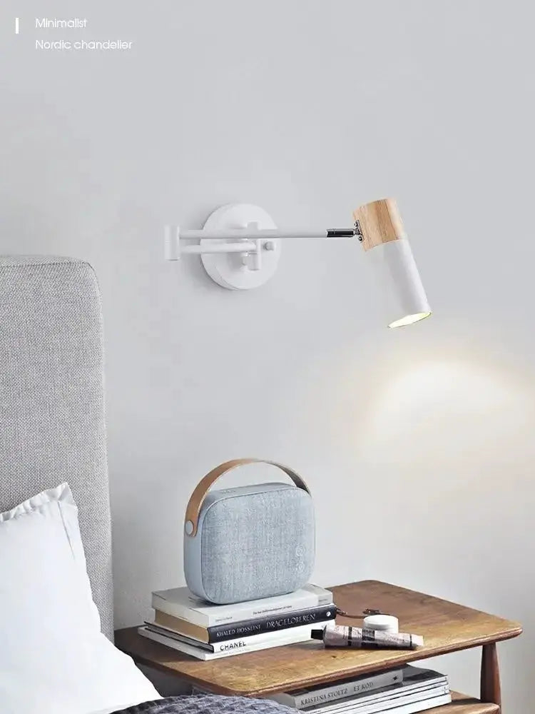 Wall lamp by Simples Market: modern white fixture with wood accent and adjustable arm above bedside table
