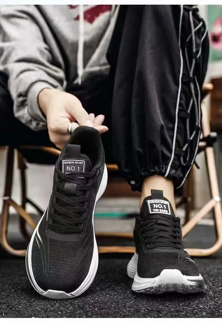 Pair of breathable mesh men's sneakers, black upper with white sole, lightweight casual running shoes