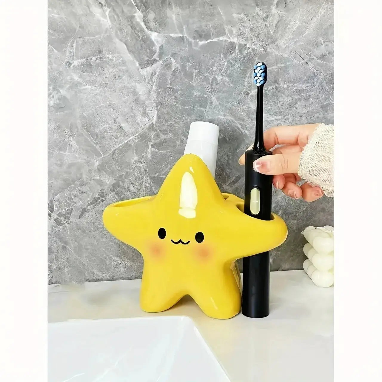 Star-shaped toothbrush holder by Simples Market; yellow with a cute face, holds toothbrush and toothpaste