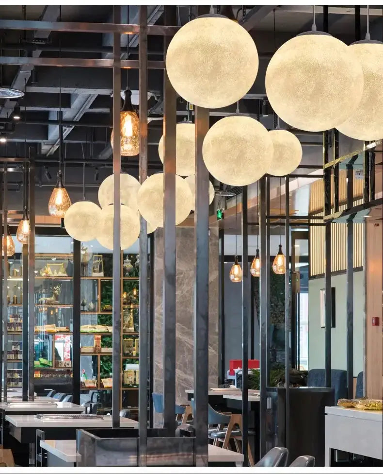 Nordic Moon LED pendant lights by Simples Market; multiple frosted white globe lamps in a modern cafe interior