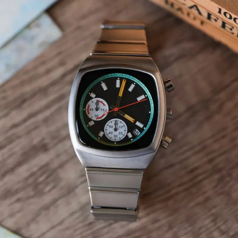 Men's square quartz watch with a silver stainless-steel band, black dial, green ring and chronograph subdials.