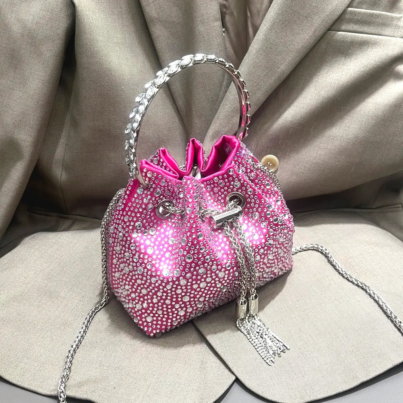 Pink rhinestone evening clutch bag with crystal-dotted bucket design and silver chain handle