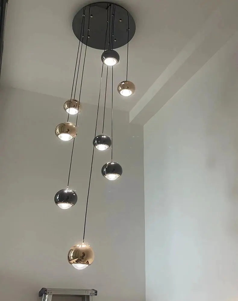 Modern multi-pendant LED ball lights with gold and black mirrored spheres hanging at varying lengths
