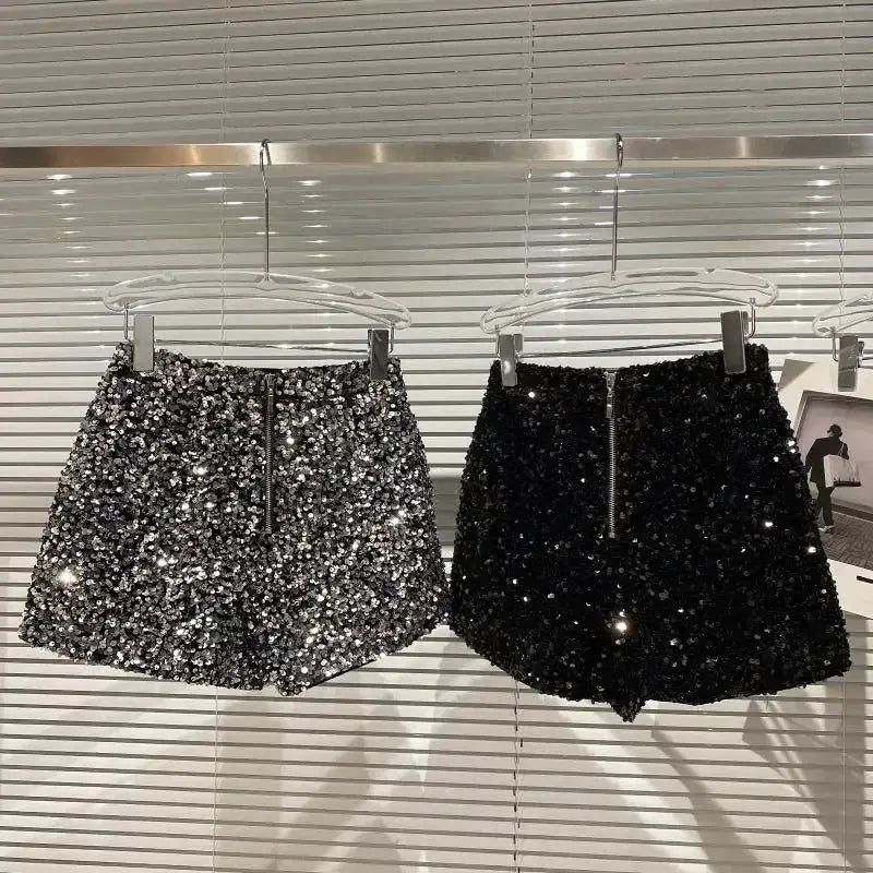 Two pairs of women's sequined shorts, silver and black, on display