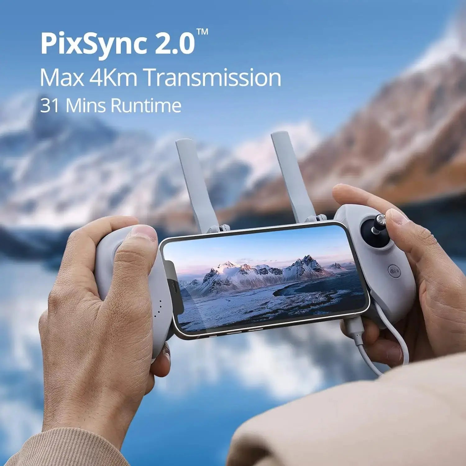 Drone controller with mounted smartphone, white/gray finish, dual antennas, mountains in background.