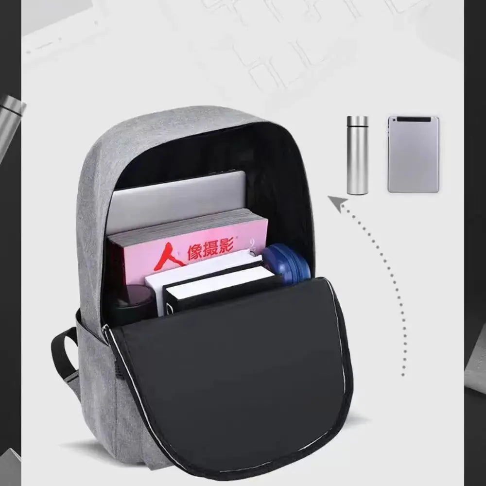 Grey minimalist backpack with large capacity; open main compartment shows books and a notebook.