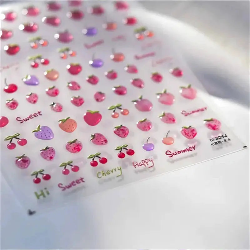 Nail art stickers sheet with kawaii fruit designs in pink and purple tones
