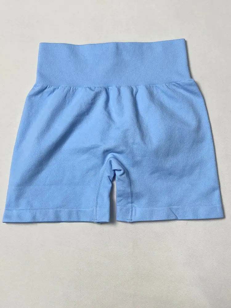 Blue high-waisted women's yoga shorts with ribbed waistband and seamless hip-lift.