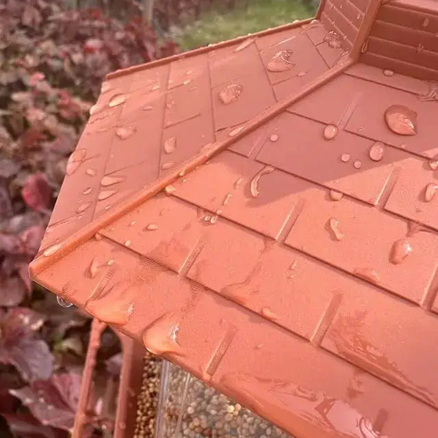 Automatic bird feeder gazebo-style hanging feeder with orange roof outdoors