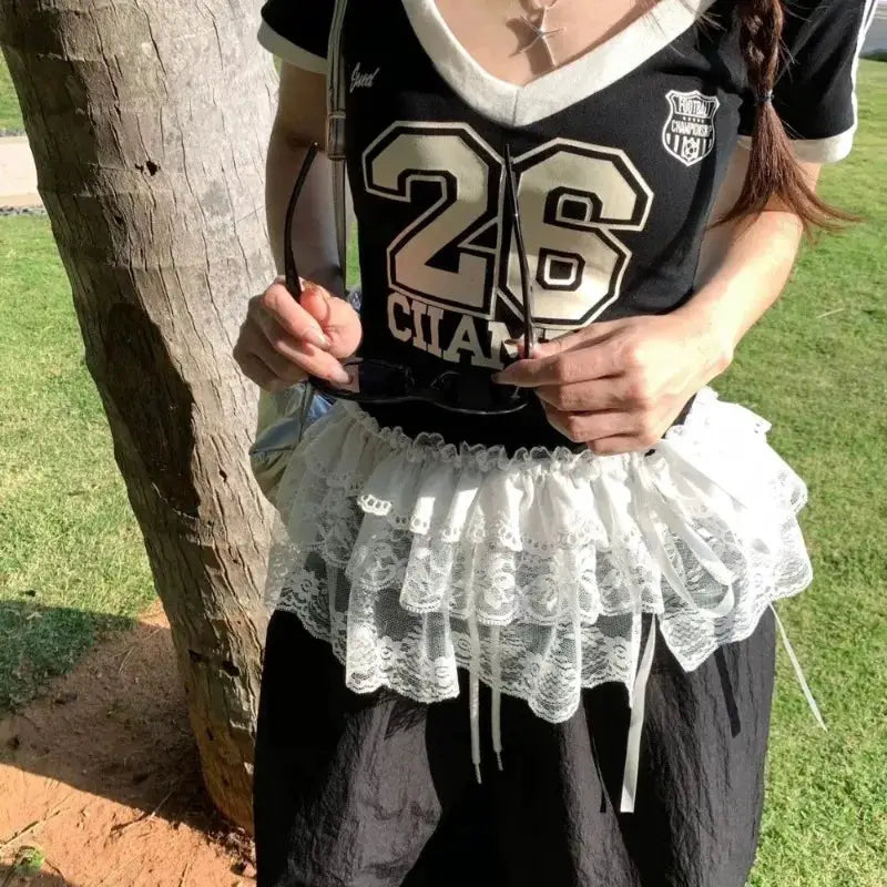 White lace layered waist belt over a black high-waisted skirt, Y2K Harajuku style