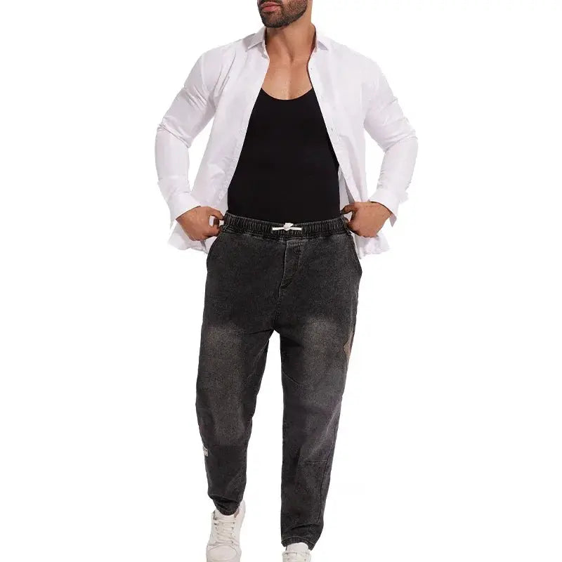 Men's full-body shapewear undergarment displayed on model wearing white shirt over black sleeveless top and dark gray joggers