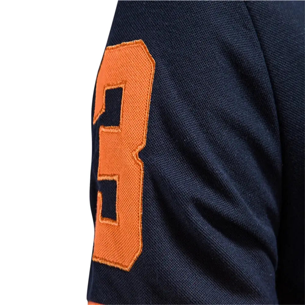 Navy polo shirt with orange embroidered patch on the sleeve