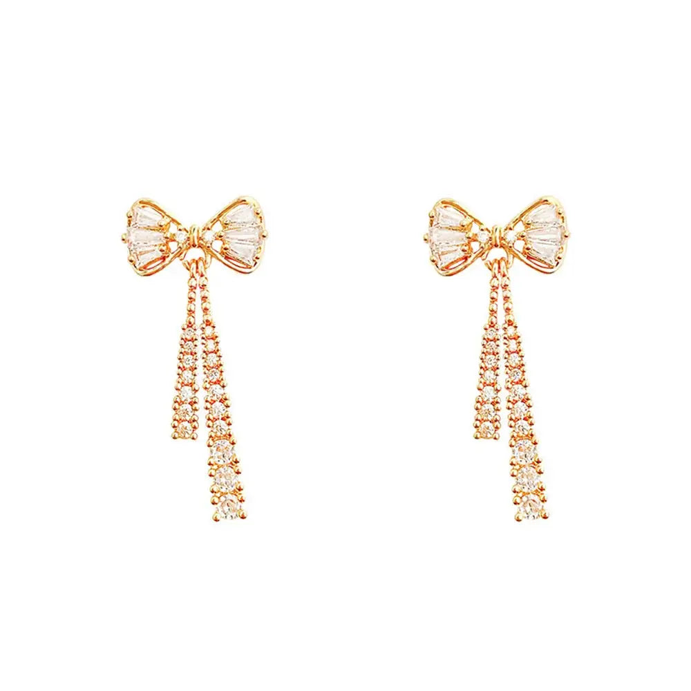 Pair of Simples Market bow-shaped crystal zircon earrings, gold-tone with dangling rhinestone chains