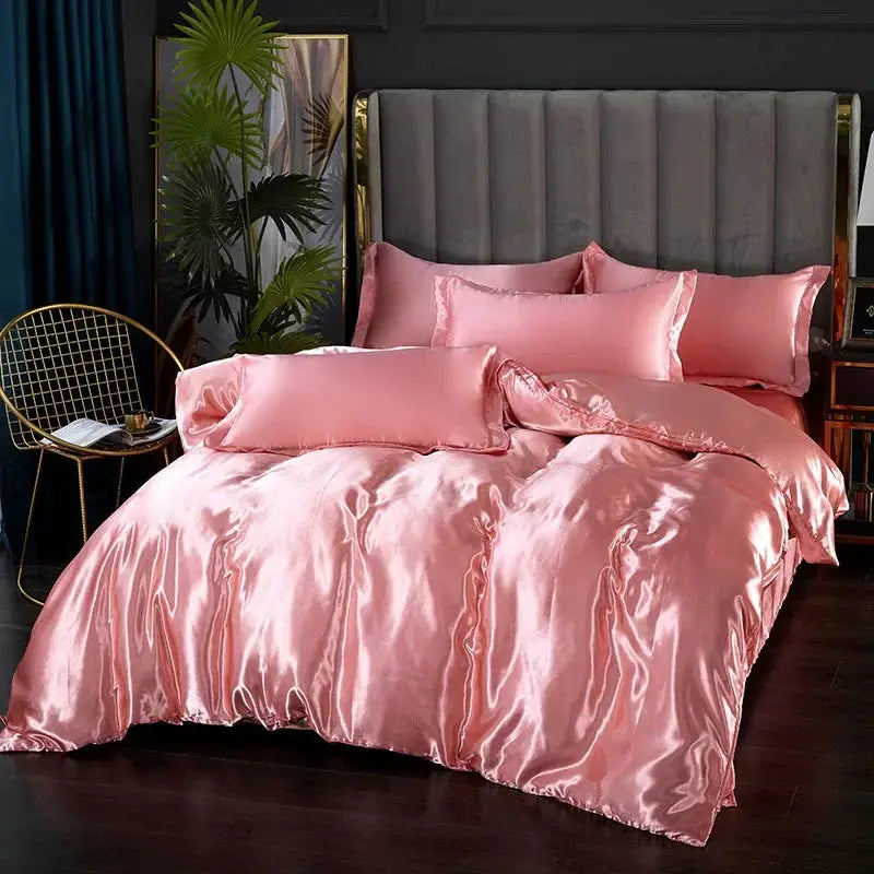 Pink satin bedding set with duvet cover and pillowcases on a bed